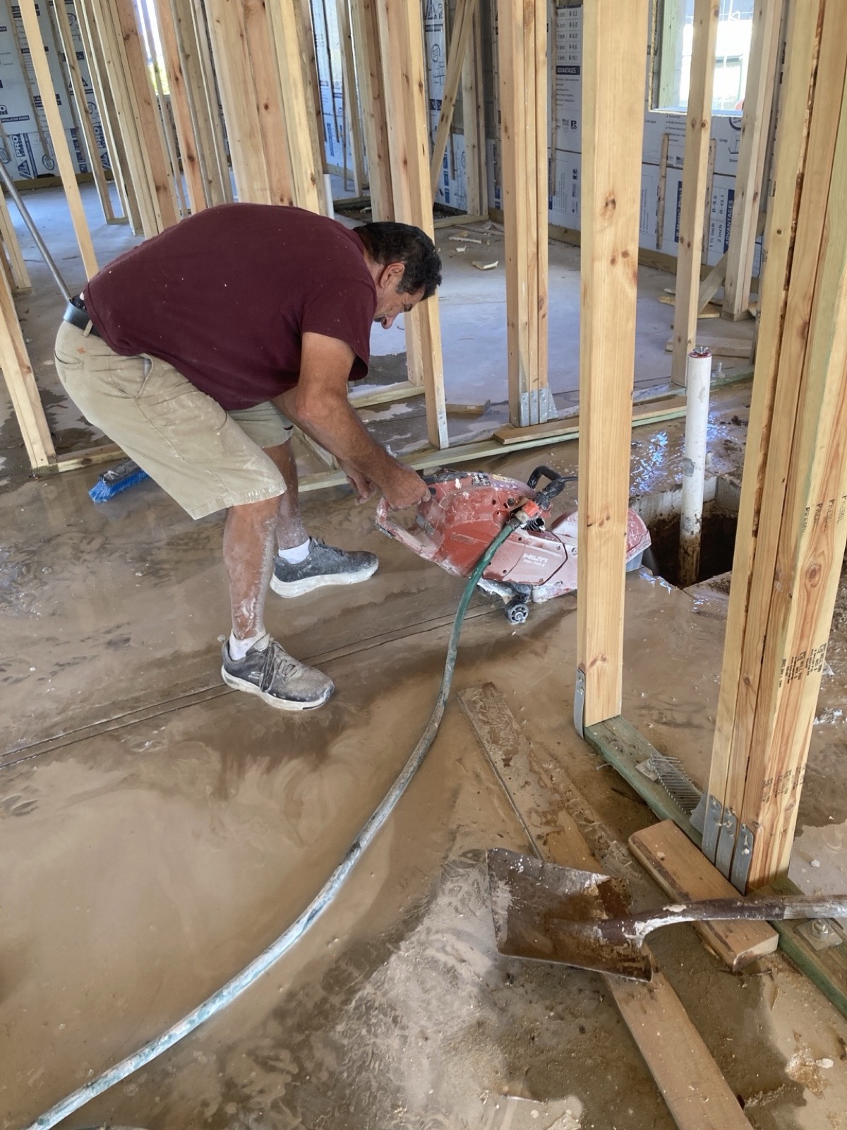 Contractor cutting a concrete slab during residential construction